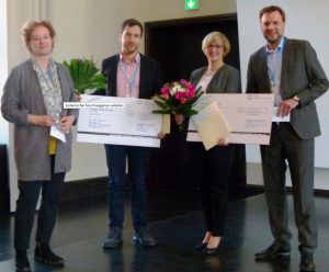 Ulrike Borst (l.) und Björn Enno Hermans (r.) verleihen den Forschungspreis in der Heidelberger Universität an Audris Muraitis (2.v.l.) und Barbara Wilhelm (3.v.l.)